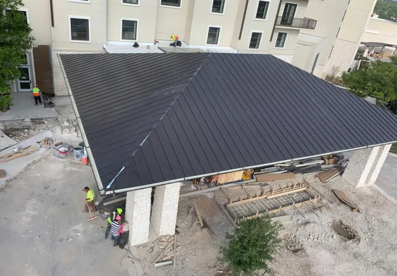 Metal roofing installation team working on a commercial building in Swansea